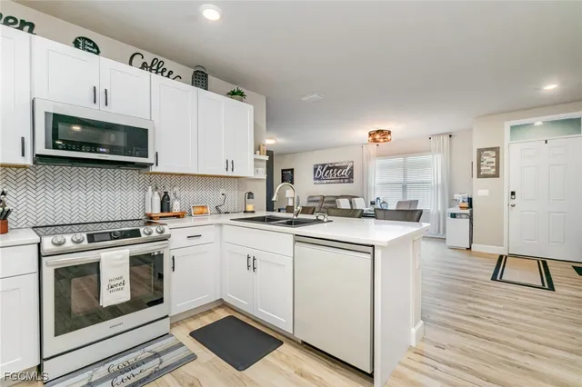 a kitchen with stainless steel appliances granite countertop a stove a sink and a microwave