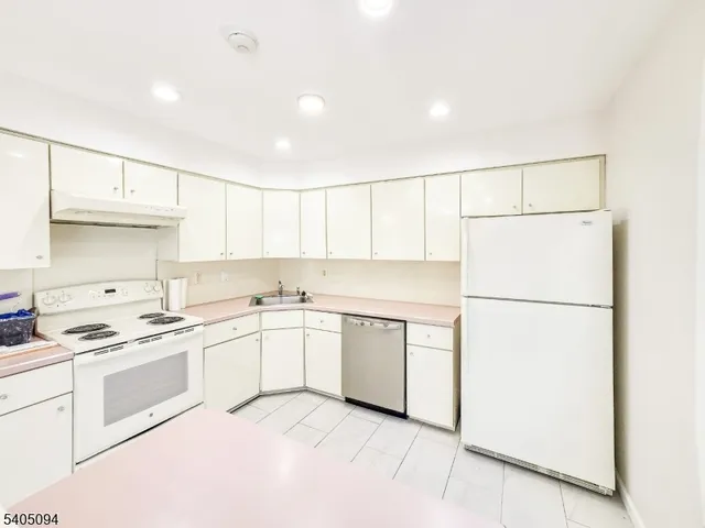 a kitchen with a white cabinets sink and white appliances