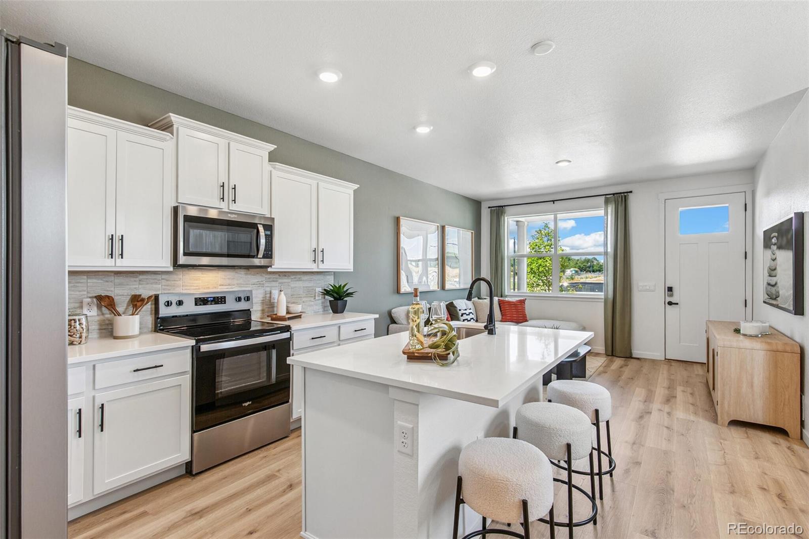 1374 South Chester Street, Unit A Denver, CO 80247 - Photo 11 of 35 a kitchen with a sink white cabinets and stainless steel appliances