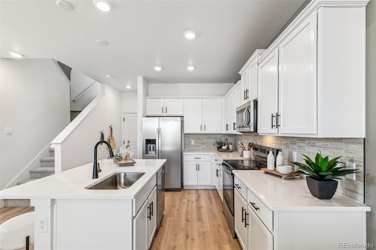 1374 South Chester Street, Unit A Denver, CO 80247 - Photo 8 of 35 a kitchen with a sink a counter top space cabinets and stainless steel appliances