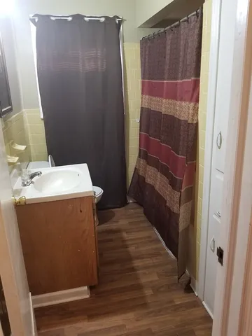 a bathroom with a sink a toilet a shower and a window