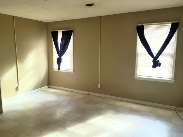 an empty room with windows and closet