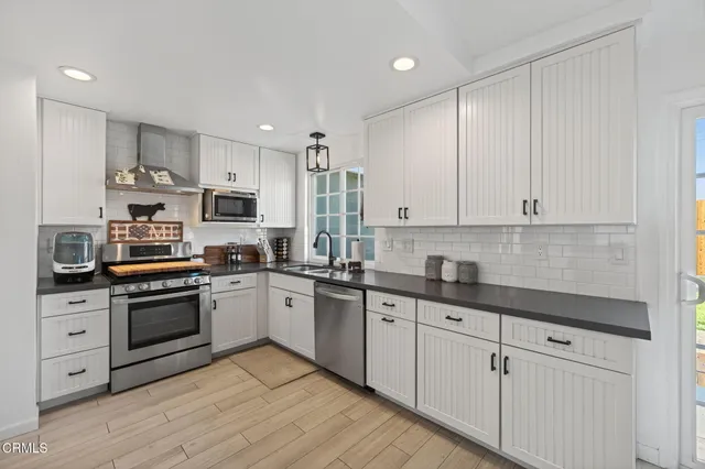a kitchen with granite countertop white cabinets and white appliances