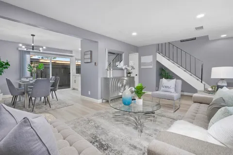 a living room with furniture and dining table