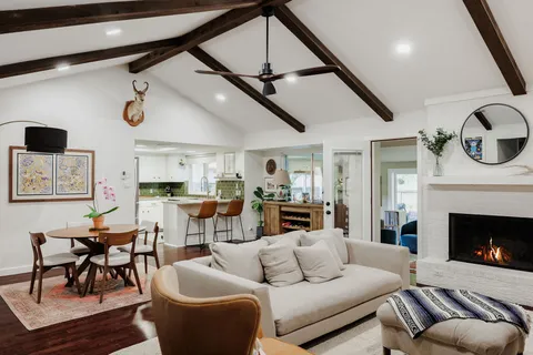a living room with furniture a fireplace and kitchen view