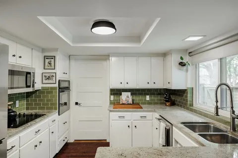 a kitchen with stainless steel appliances granite countertop a sink stove and cabinets