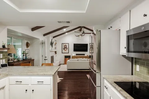 a kitchen with kitchen island white cabinets and stainless steel appliances