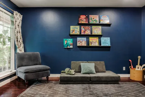 a living room with furniture and a painting on the wall