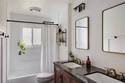 a bathroom with a granite countertop sink toilet and shower