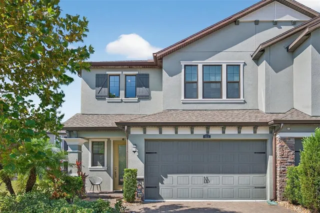 a front view of a house with a garden and garage