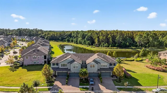 an aerial view of residential house with outdoor space and trees all around