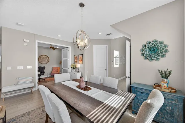 a kitchen with stainless steel appliances a stove a sink a microwave a refrigerator a stove a dining table and chairs