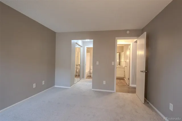 an empty room with closet and a bathroom