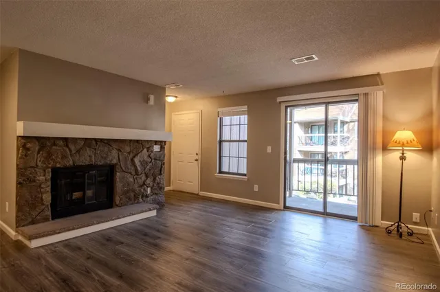an empty room with wooden floor and fireplace