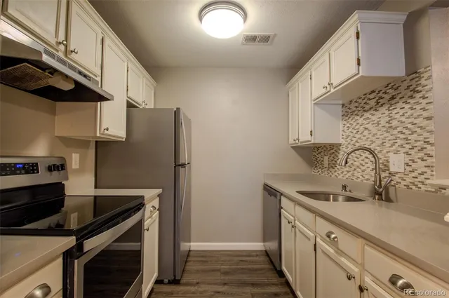 a kitchen with stainless steel appliances a sink and cabinets