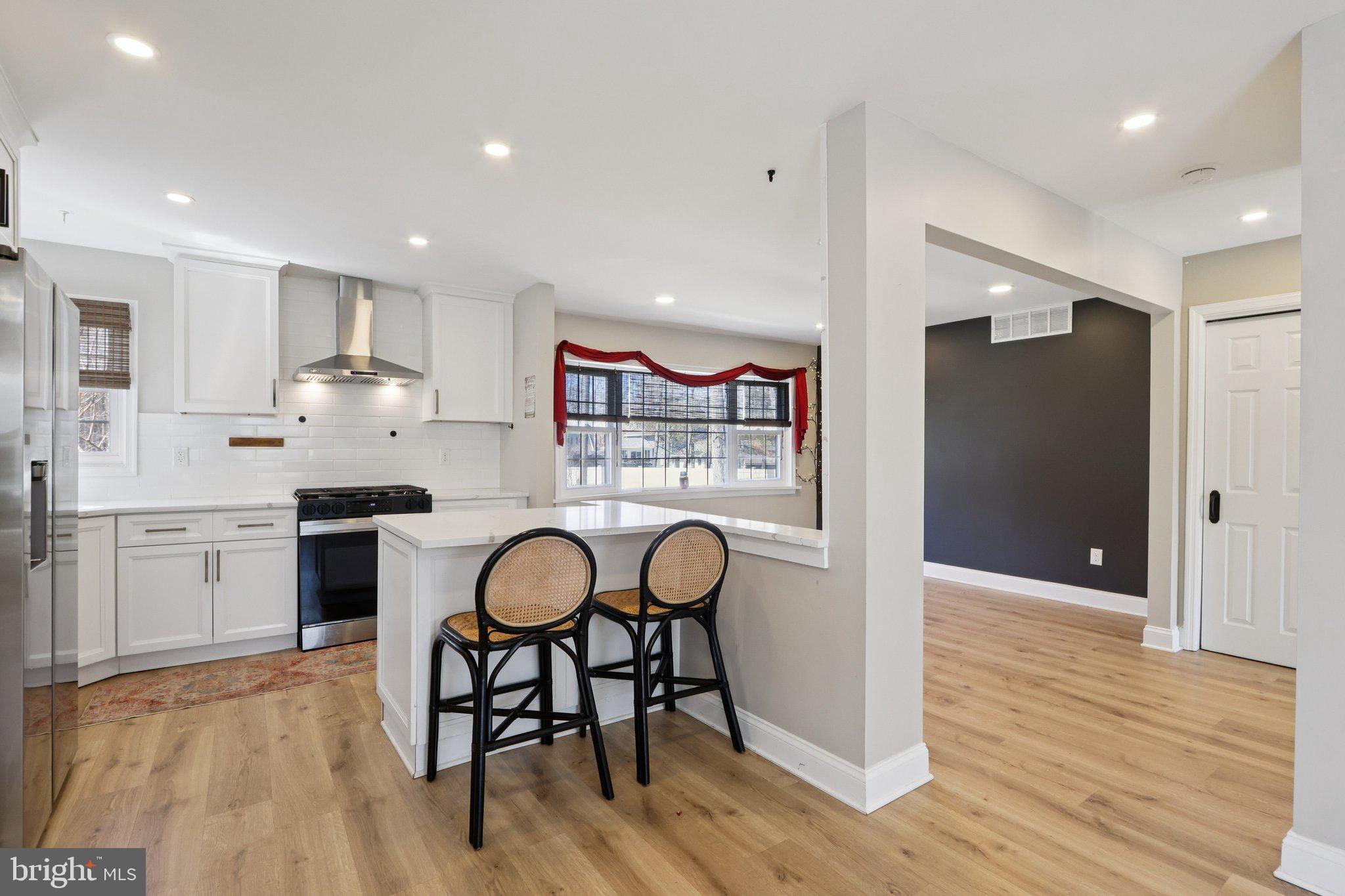 351 Merrick Road Robbinsville, NJ 08691 - Photo 26 of 69 a kitchen with stainless steel appliances granite countertop a stove a refrigerator and a dining table with wooden floor