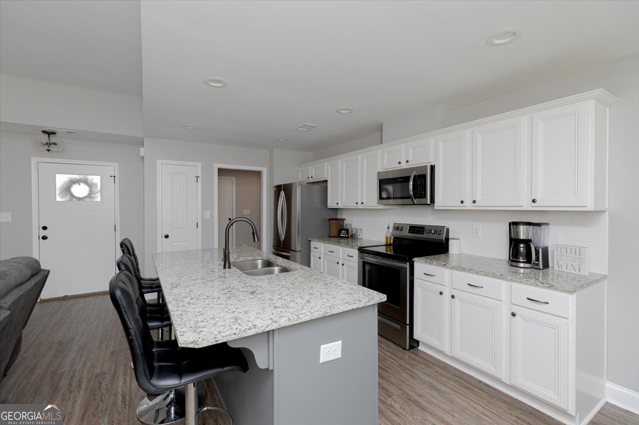 104 Meredith Layne Court Perry, GA 31069 - Photo 18 of 46 a kitchen with granite countertop cabinets stainless steel appliances and dining table