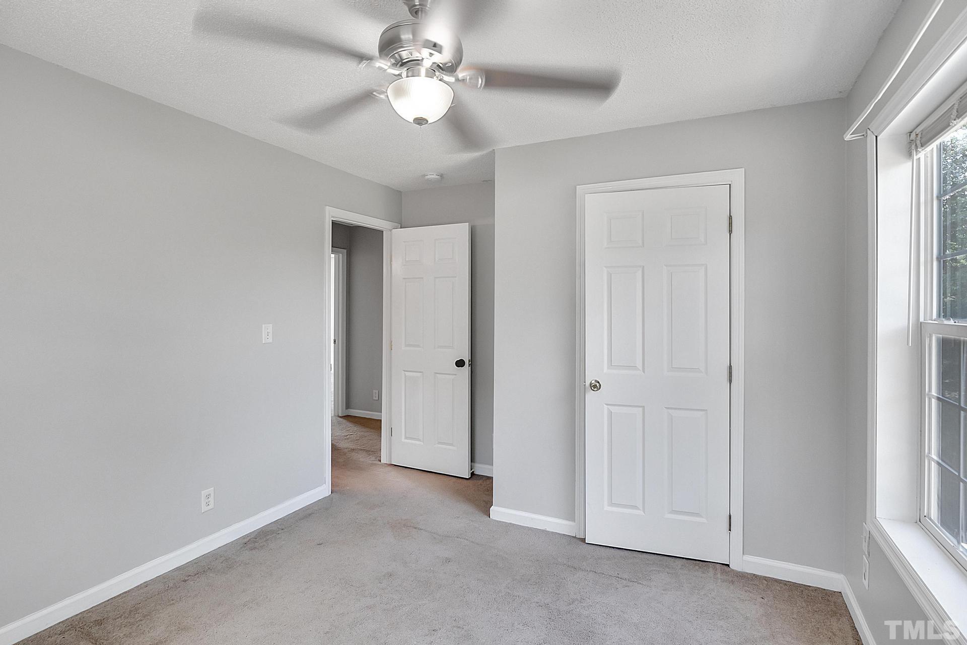 7009 Onslow Stephenson Road Willow Spring, NC 27592 - Photo 32 of 43 an empty room with a ceiling fan and a window