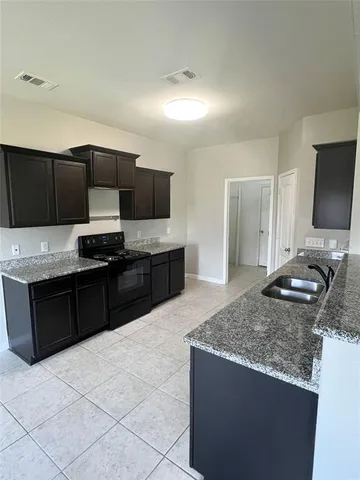 a kitchen with stainless steel appliances granite countertop a sink and a stove