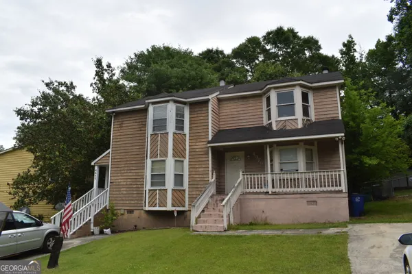 a front view of a house with a garden and yard