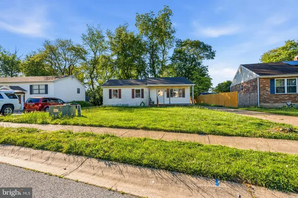 a view of house with a yard and potted plants