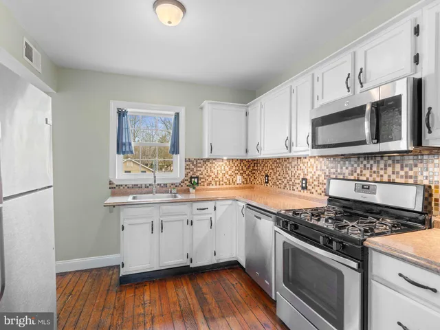 a kitchen with stainless steel appliances granite countertop a sink stove and microwave