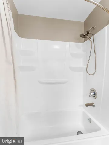 a bathroom with a bath tub with a shower