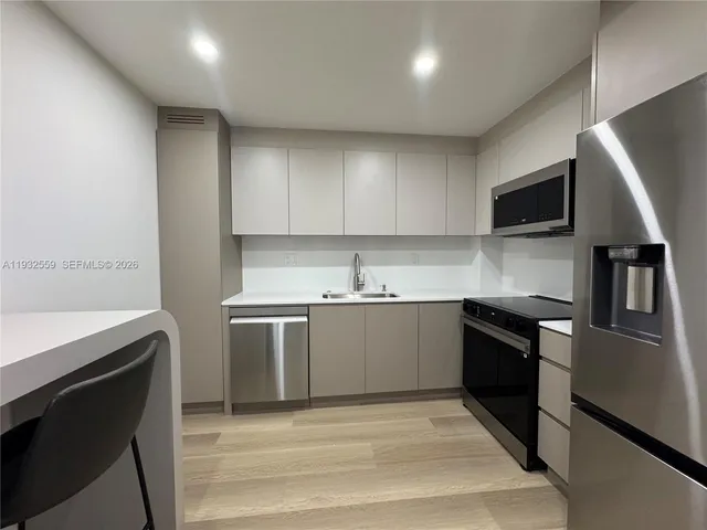 a kitchen with granite countertop a sink and stainless steel appliances