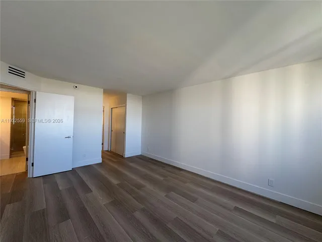 a view of an empty room and wooden floor