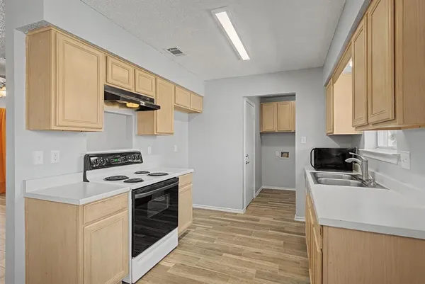 a kitchen with a stove a sink and cabinets