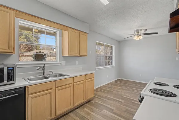 a kitchen with a stove a sink and a window