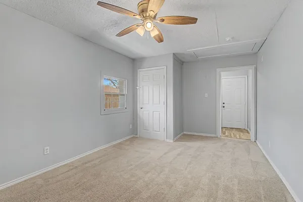 a view of an empty room with a ceiling fan