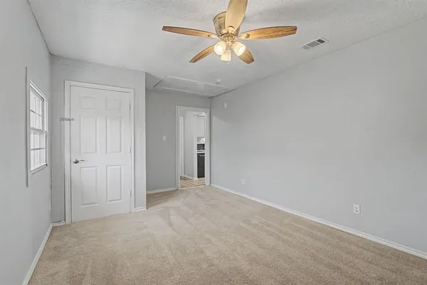 an empty room with closet and a chandelier fan
