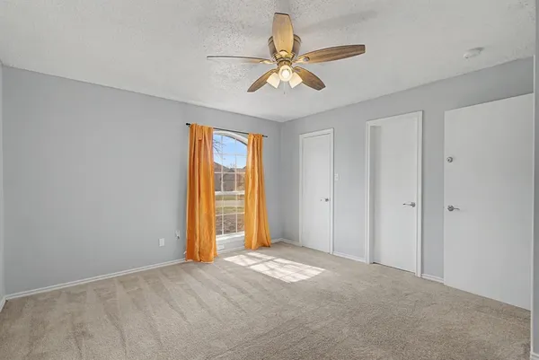 a view of a room with a ceiling fan and a window