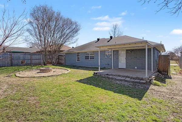 a view of a house with a yard and large tree