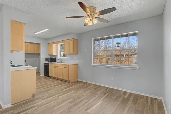 a kitchen with stainless steel appliances granite countertop a stove a sink dishwasher and a refrigerator with wooden floor