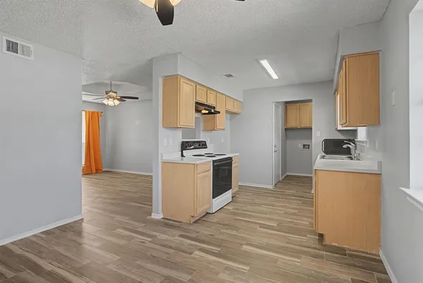 a kitchen with a refrigerator and a stove top oven