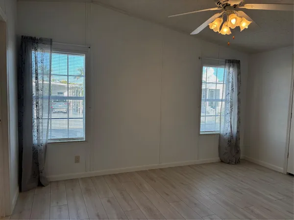an empty room with a window and a ceiling fan