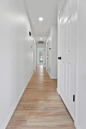 a view of a hallway with wooden floor