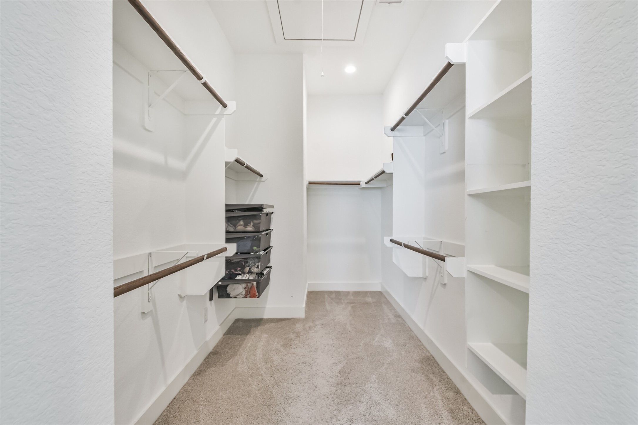 8411 Hempstead Road, Unit H Houston, TX 77008 - Photo 34 of 40 A spacious walk-in closet with floor-to-ceiling shelves neatly organized with shoes, bags, and folded clothes.