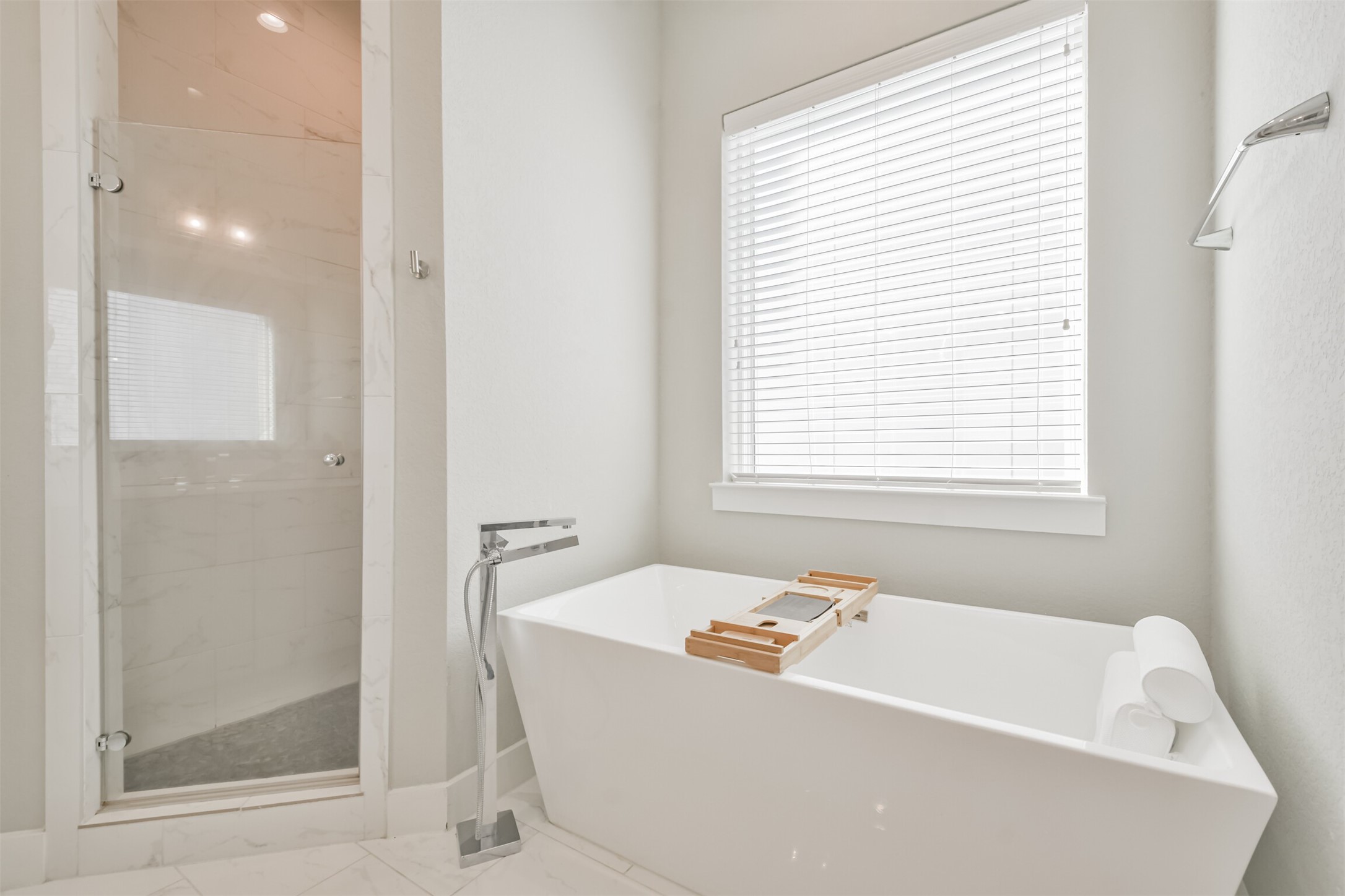 8411 Hempstead Road, Unit H Houston, TX 77008 - Photo 37 of 40 A freestanding, modern bathtub with a sensual, curvaceous shape is placed near a window, inviting natural light into the space.