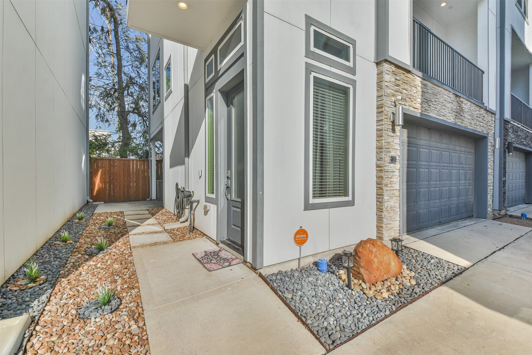 8411 Hempstead Road, Unit H Houston, TX 77008 - Photo 4 of 40 A clean, welcoming entrance featuring neatly arranged rock landscaping. The pathway is framed by smooth stones, leading up to the homes main entrance.