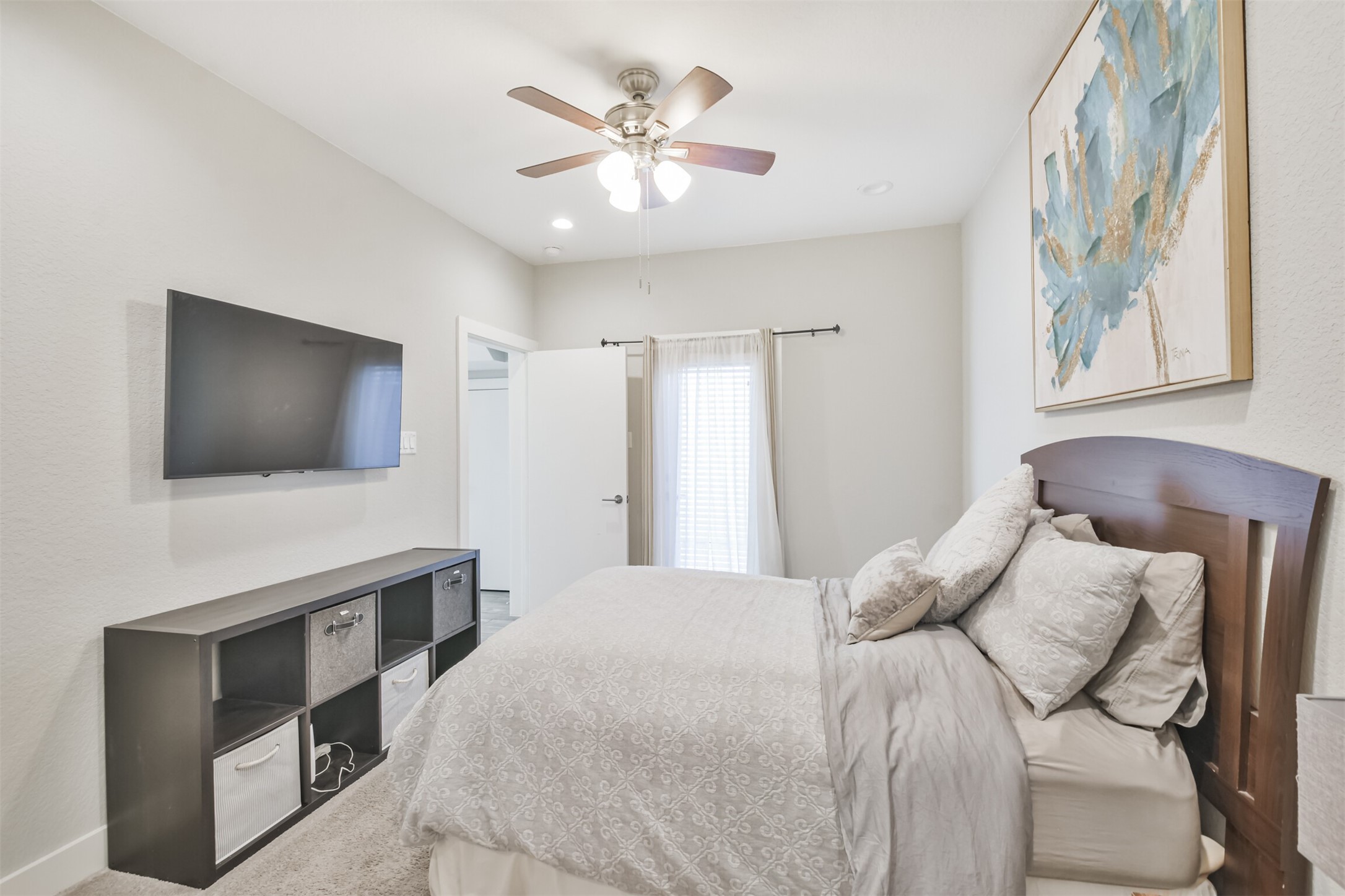 8411 Hempstead Road, Unit H Houston, TX 77008 - Photo 8 of 40 A cozy ground-floor room with it's own en suite bathroom. A cozy ground-floor room featuring a comfortable bed with soft linens, a stylish nightstand, and a large window that lets in natural light. The room is complemented by its own en suite bathroom, equipped with modern fixtures, a sleek shower, and a clean, minimalist design, offering both convenience and privacy.