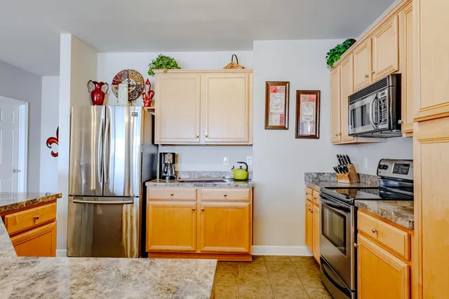 a kitchen with stainless steel appliances granite countertop a refrigerator sink and stove