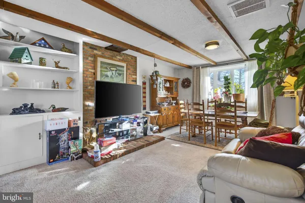 a dining room with stainless steel appliances kitchen island granite countertop a table and chairs