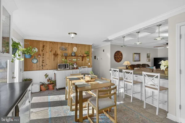 a kitchen with stainless steel appliances granite countertop a refrigerator a stove top oven and a dining table with wooden floor