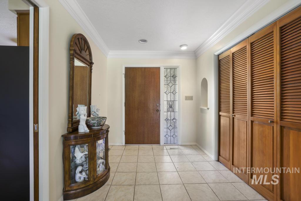 2018 Rancho Vista Drive Twin Falls, ID 83301 - Photo 7 of 50 Entryway featuring square tile flooring, a solid wood entry door, and a sidelight with decorative glass and security bars