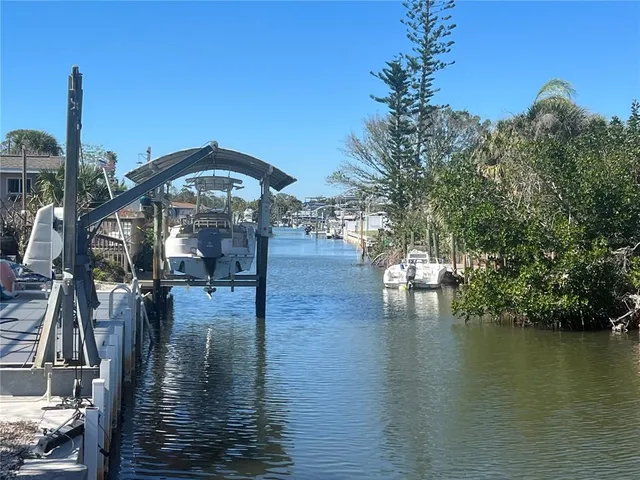 a view of a lake with a yard and large trees