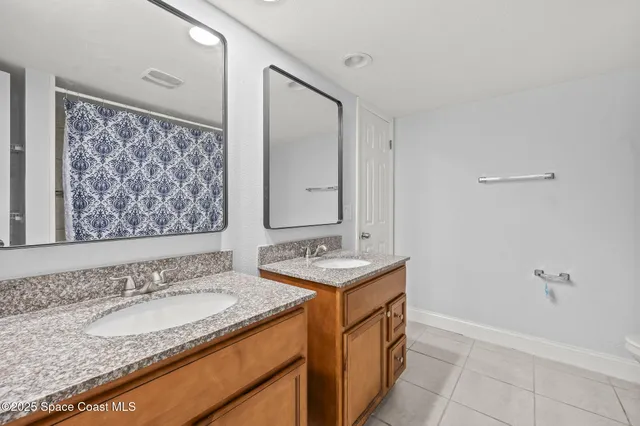 a bathroom with a granite countertop sink a mirror and a shower