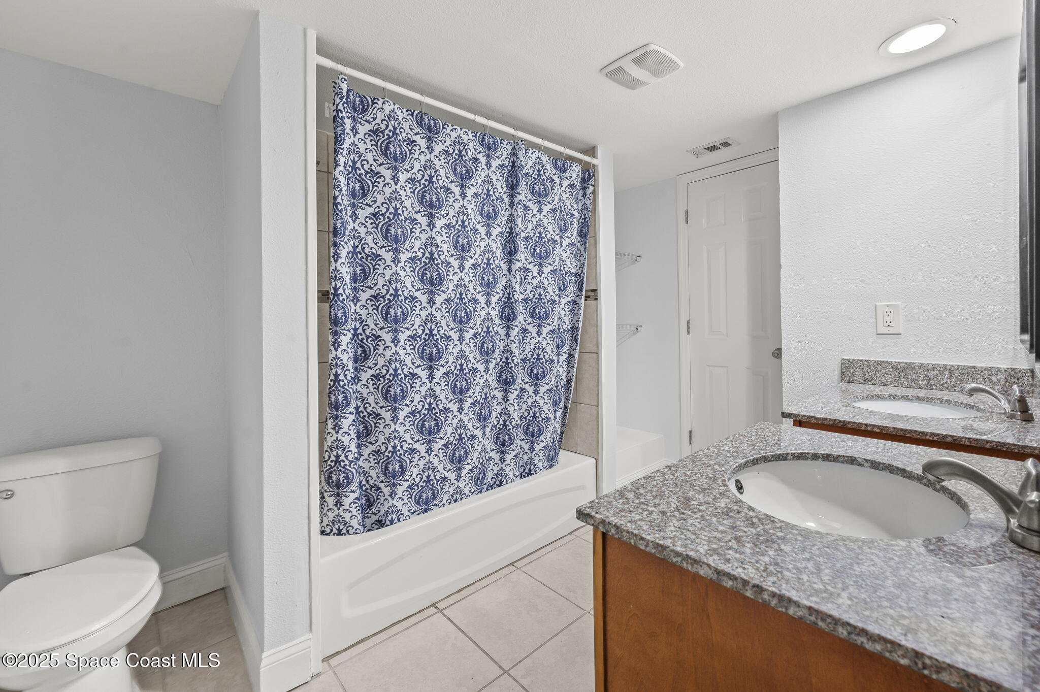 1170 South Patrick Drive, Unit 29 Satellite Beach, FL 32937 - Photo 12 of 18 a bathroom with a granite countertop sink toilet and shower